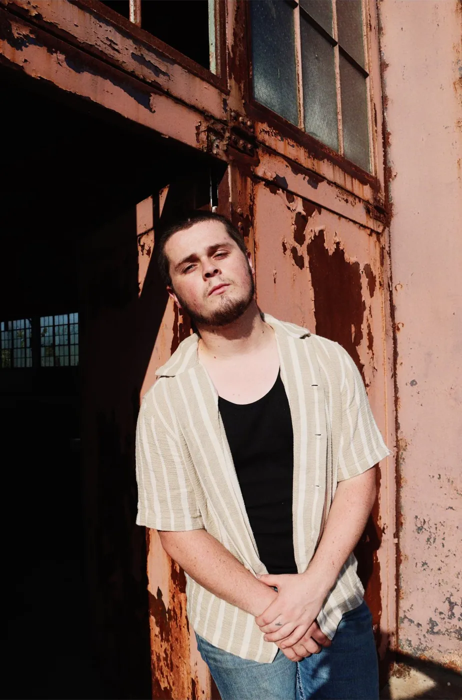 Tyler Nichols leaning against a rusted door