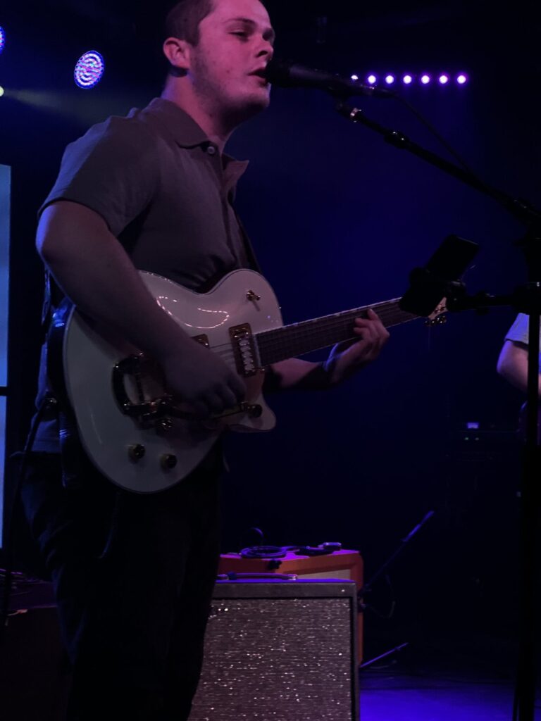 Tyler Nichols performing on stage under blue lights
